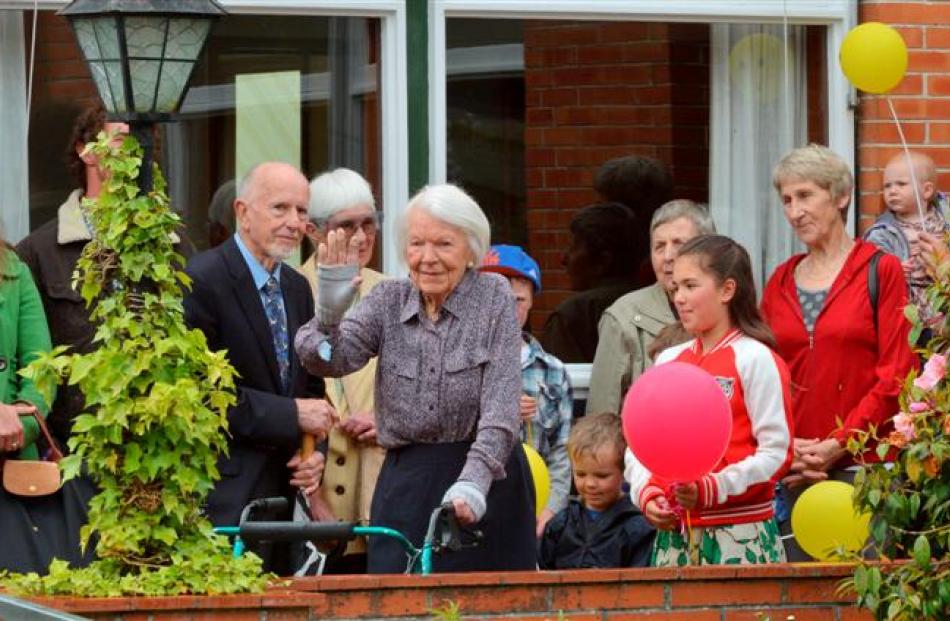 Joan Boddy waves as friends and family arrive to celebrate her 100th birthday. Photo by Gerard O...