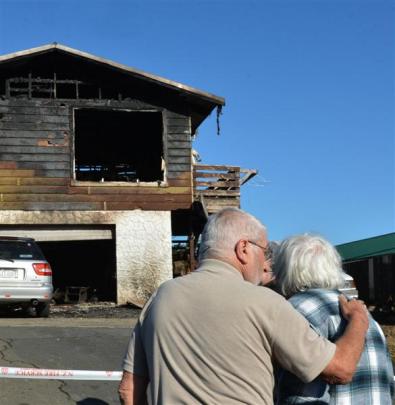 John Caley (right) is comforted by friend Bill Atherton as he examines the ruins of his Ocean...