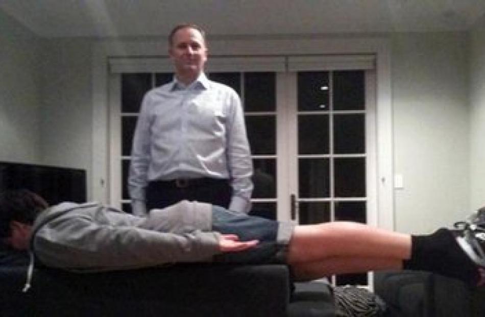 John Key's son, Max, makes his 'PM plank' while his father stands behind him, creating what one...
