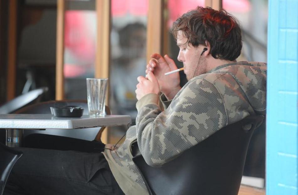 Jordan Younger smokes outside an Octagon restaurant, in Dunedin yesterday. Photo by Craig Baxter.