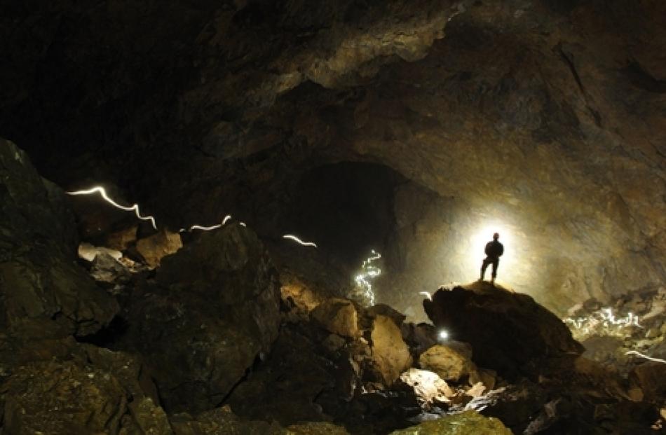 Kieran Mckay is dwarfed in a huge Stormy Pot-Nettlebed cave. Photo: Jonathon Ravens/NZ Herald