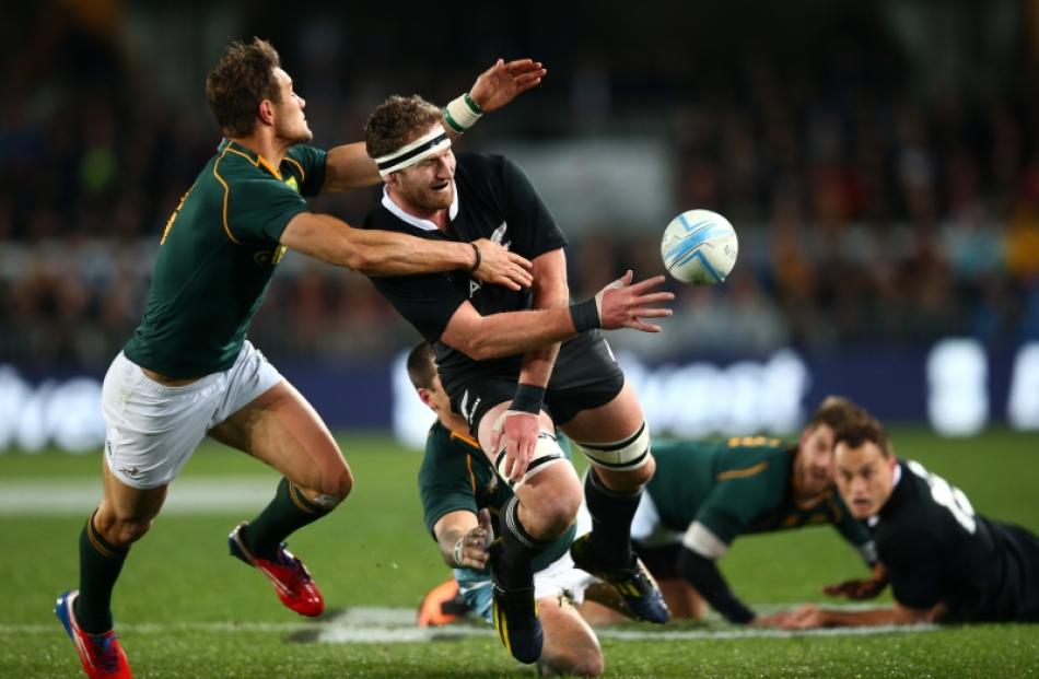 Kieran Read of the All Blacks offloads in the tackle of JJ Engelbrecht of the Springboks during...