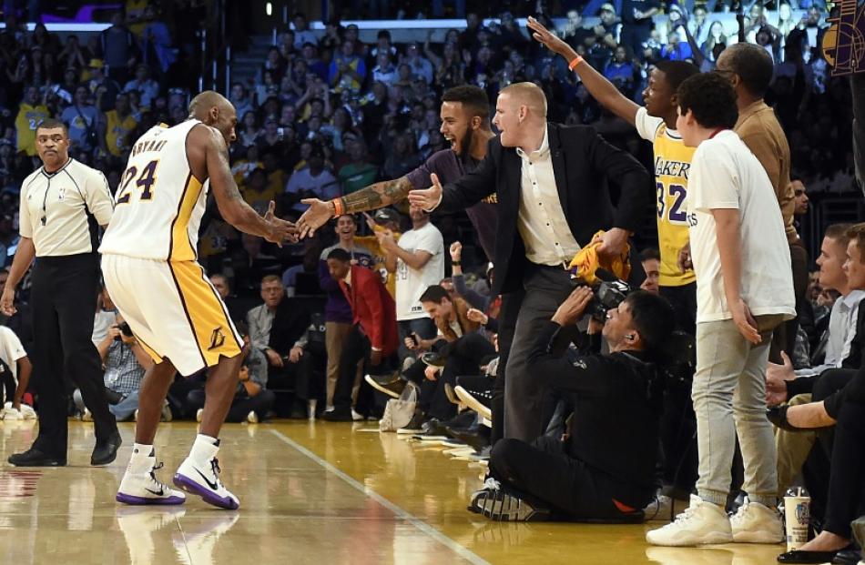 Kobe Bryant celebrates with Adam Sadler and Spencer Stone during the fourth quarter of the Lakers...