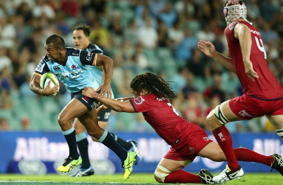 Kurtley Beale makes a break for the Waratahs against the Reds. Photo: Getty Images