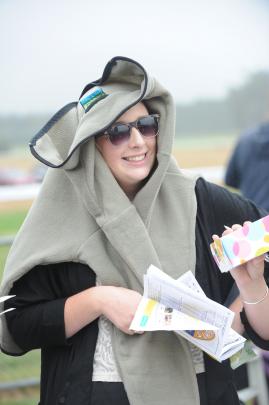 Lara Wilson of Dunedin keeps the rain at bay at the Kurow Races yesterday. Photos by Peter...