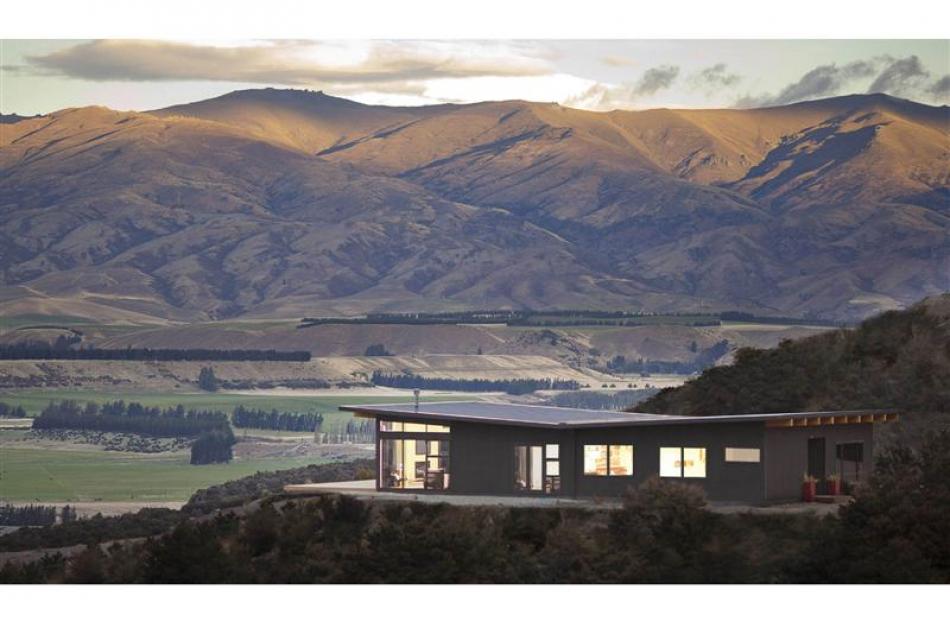 Large expanses of glass capture views of the Clutha River basin and decks hover in the landscape....