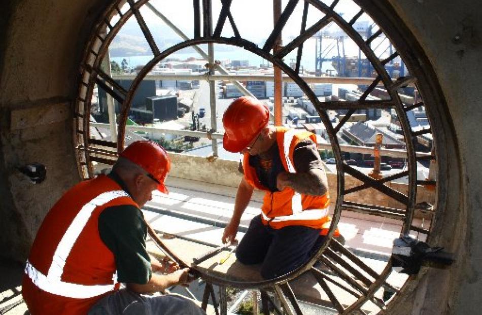 Lawrie Forbes (right) and Alan Bryan, of Zeal Steel, start to remove one of four cast-iron clock...