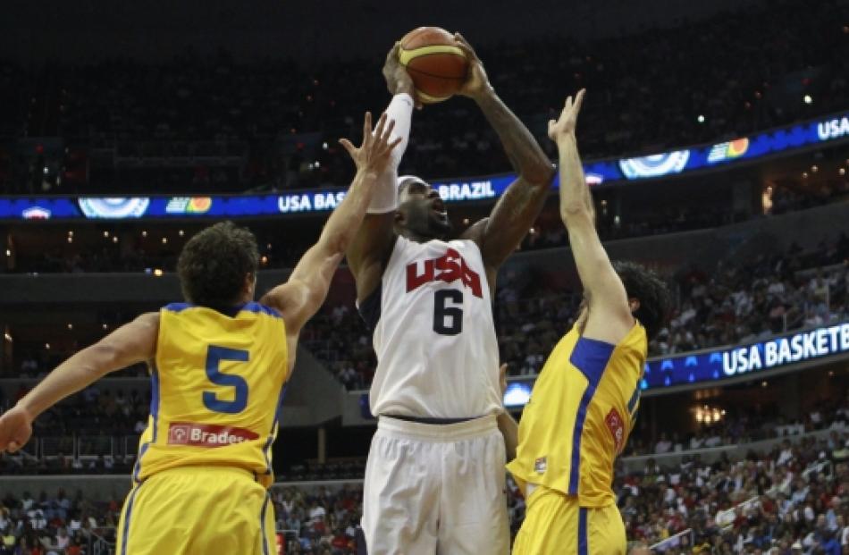 Lebron James of Team USA (centre) goes up against Raulzinho (left) and Guilherme Giovannoni of...