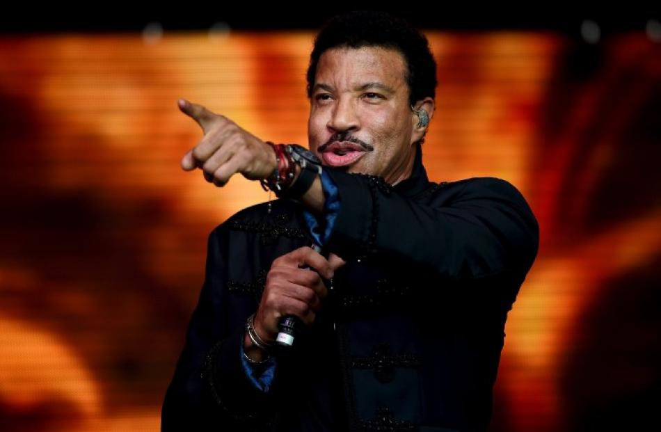 Lionel Richie gestures to the crowd while performing on the Pyramid stage at Glastonbury. Photos...