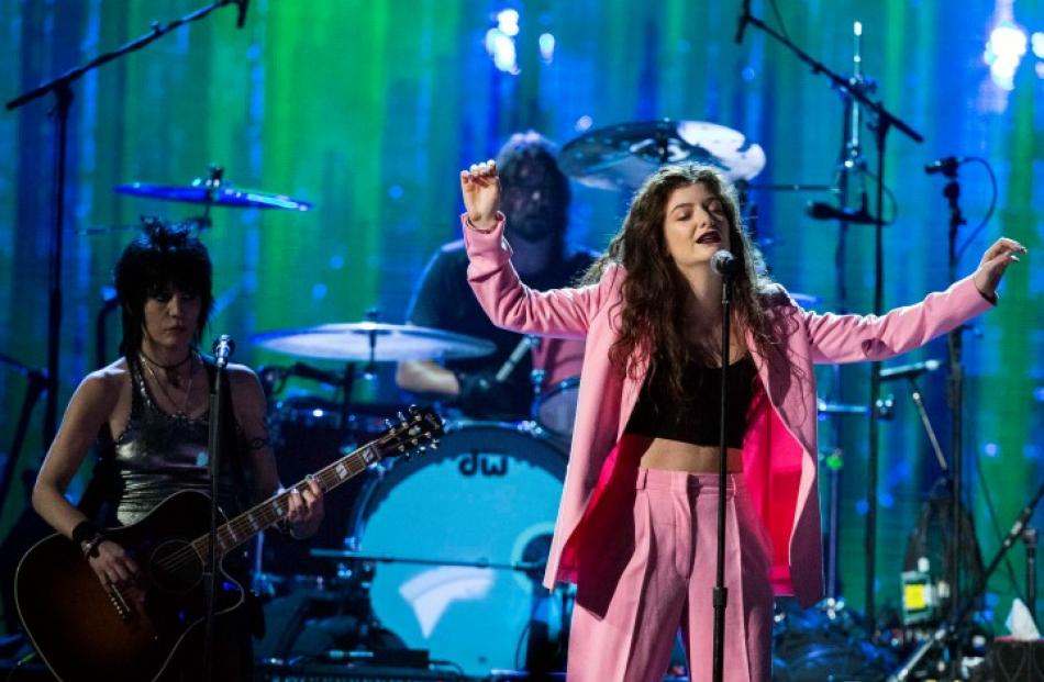 Lorde (R) performs with Joan Jett (L) and Dave Grohl after Nirvana was inducted into the Rock and...
