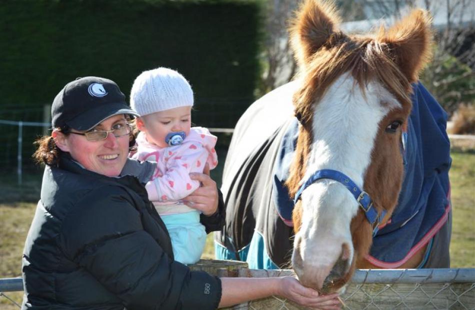Loretta Tait with daughter Alaina, who turns 1 this month, and Floyd, a horse she is getting back...
