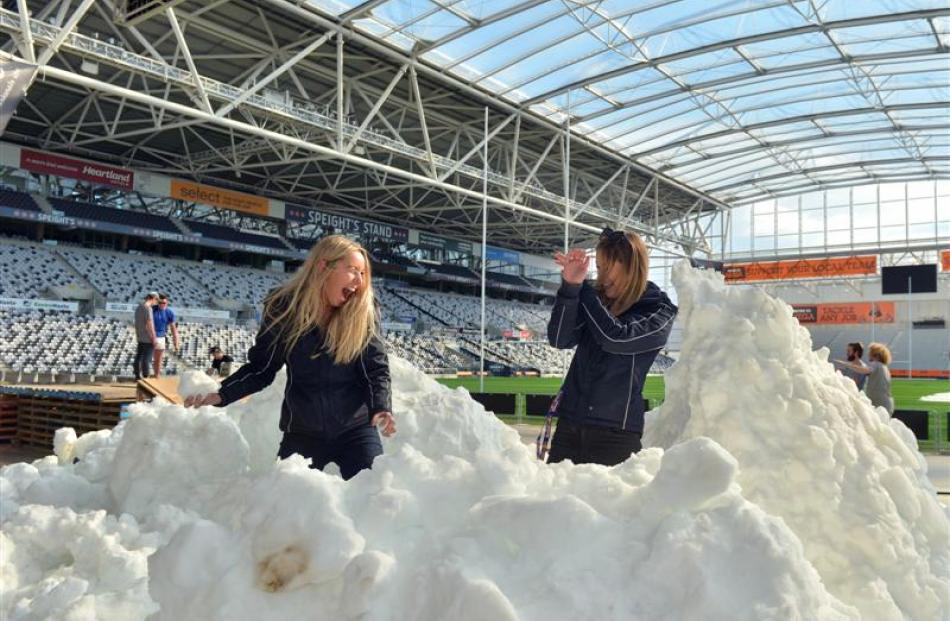 Maddie Kate Gibbons (21, right) tries to avoid being hit by a snowball thrown by Elise...
