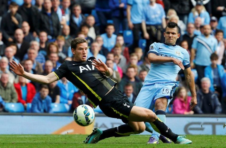 Manchester City's Sergio Aguero (R) shoots past Tottenham Hotspur's Jan Vertonghen to score his...
