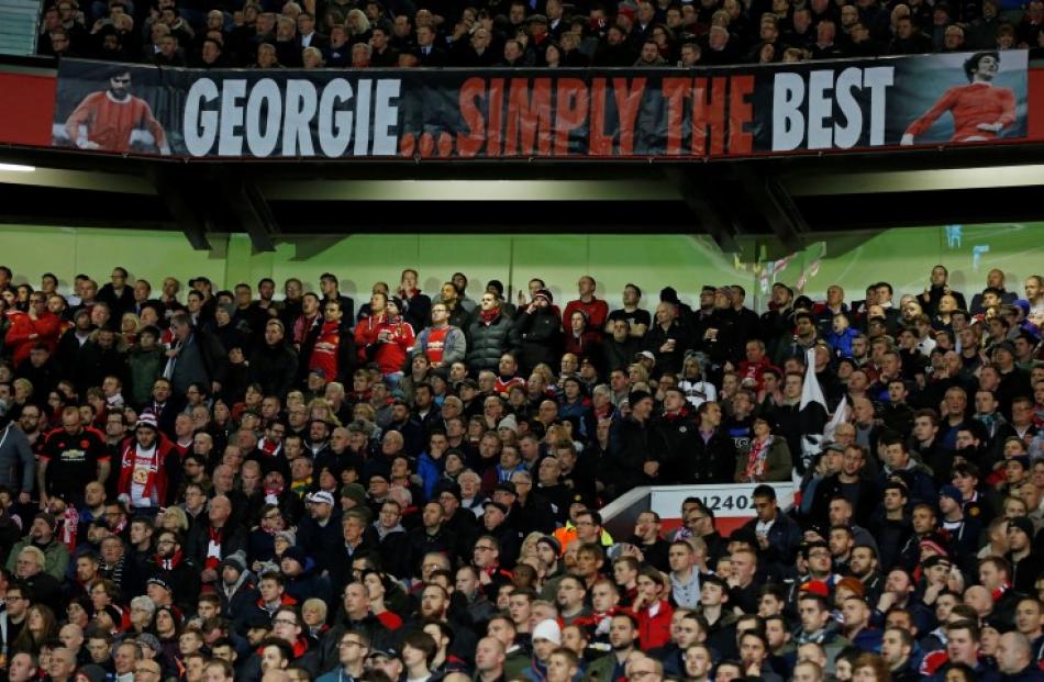 Manchester United fans pay tribute to George Best during the match against PSV Eindhoven. Photo...