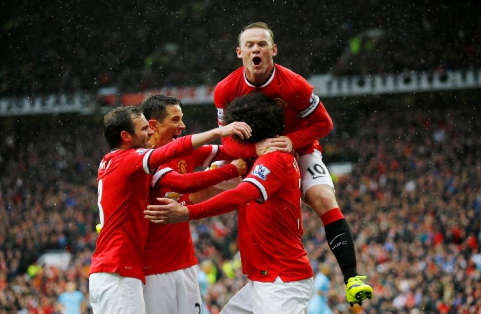 Manchester United's Marouane Fellaini is congratulated by teammates after scoring his team's...