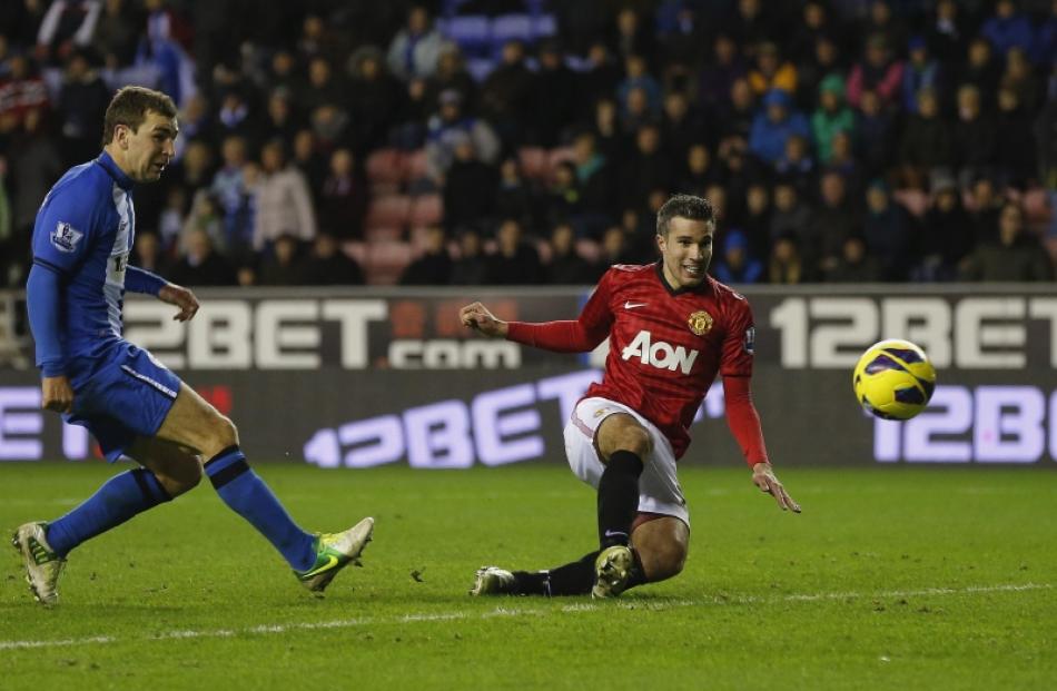 Manchester United's Robin Van Persie (right) shoots to score against Wigan Athletic during their...