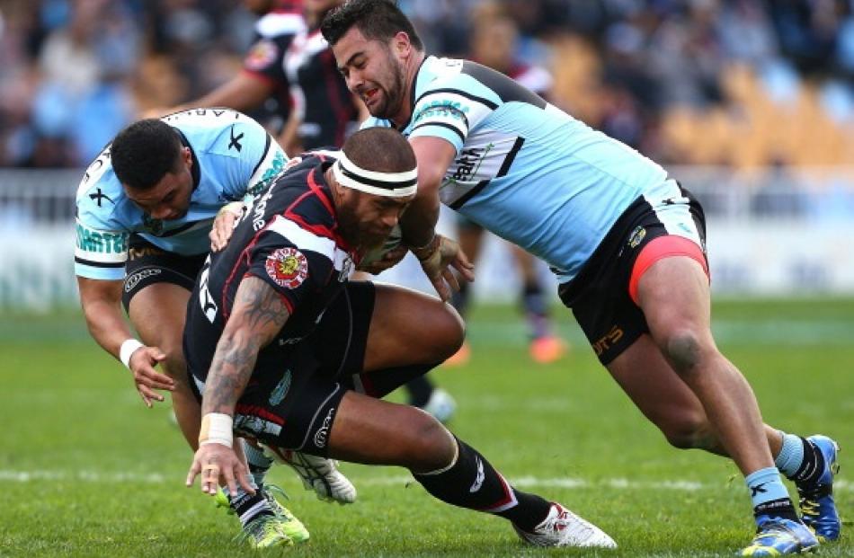 Manu Vatuvei of the Warriors is tackled by Andrew Fifita of the Sharks during the round 22 NRL...