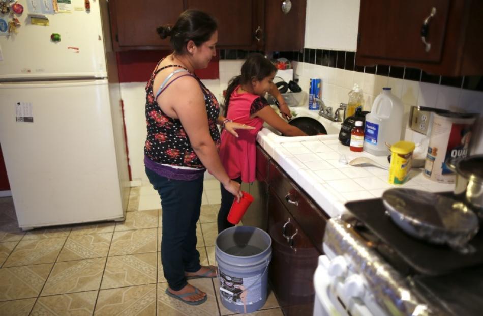 Marisela Corona, 26, (L) whose well has run dry, washes dishes with her daughter Andrea Andrade...