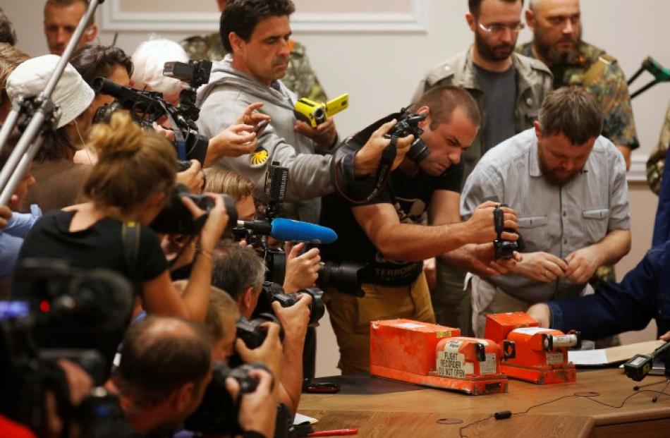 Members of the media take pictures of black boxes belonging to Malaysia Airlines flight MH17,...