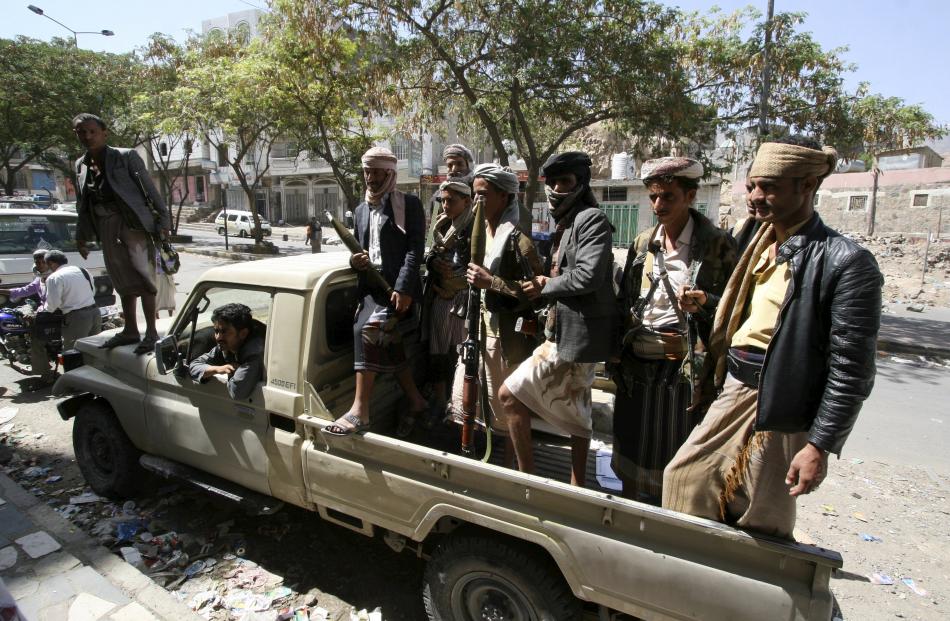 Members of the Popular Resistance Committee ride a truck as they secure a street during clashes...