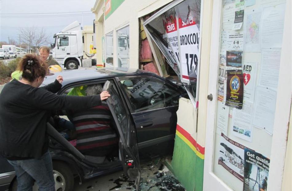 Members of the public work to free an 84 year old woman who crashed her  car into the Kurow Four...