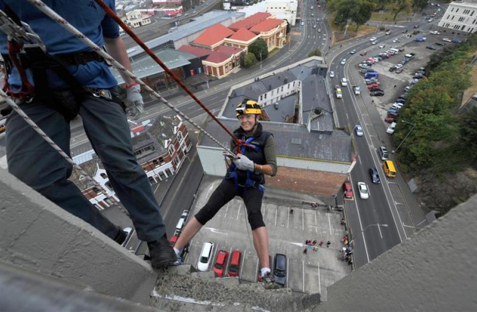 More FM Dunedin radio announcer Nicky Rennie abseils down the side of Radio Otago House with...