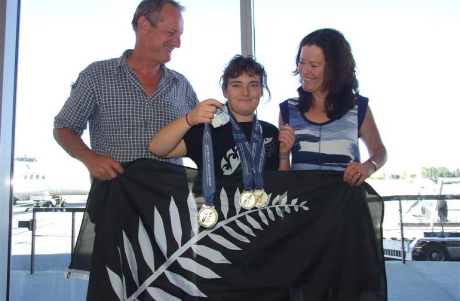 Morgan James shows off her three gold medals,  watched  by her proud parents Bruce and Sally...
