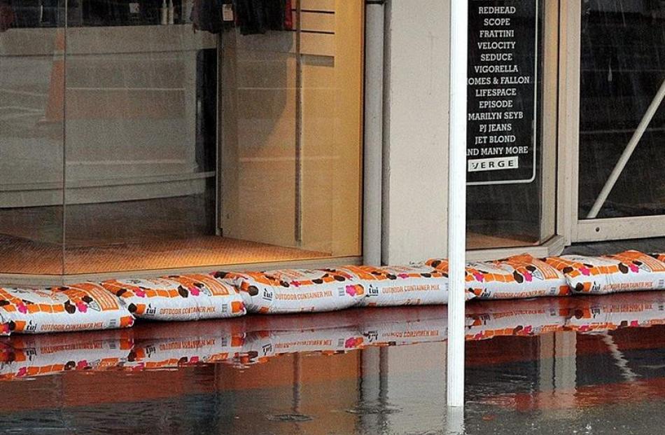 Mosgiel Mitre 10 staff put  compost bags in place to stop flooding during the June downpour....