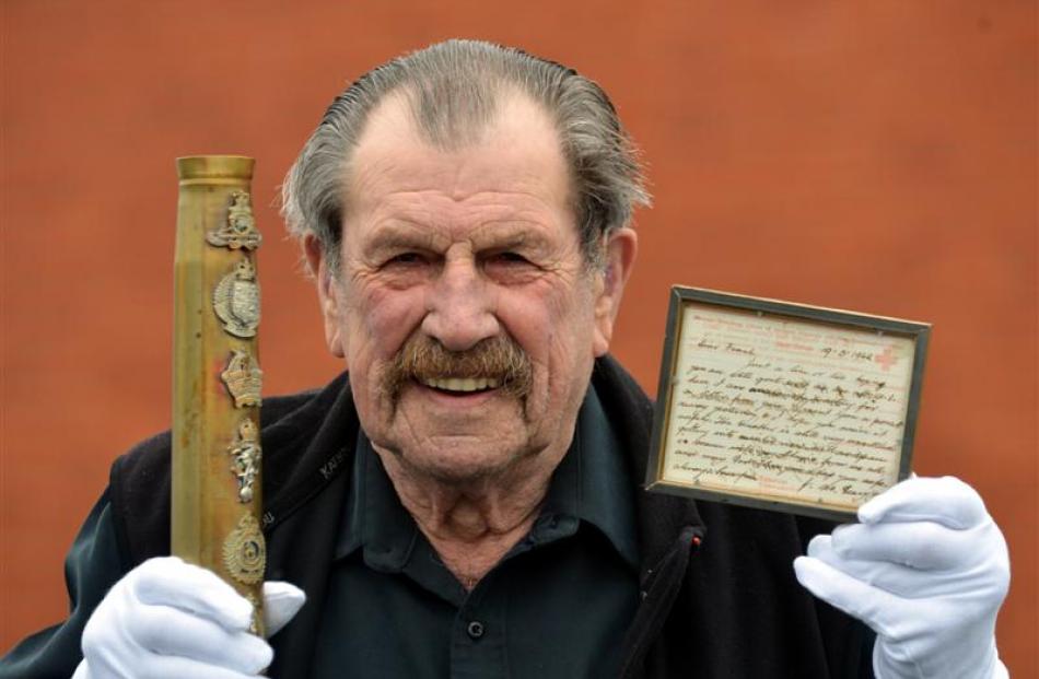 Mosgiel resident Bing Crosbie (83) holds an item of military memorabilia - New Zealand regimental...