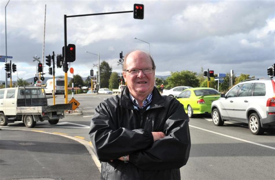 Mosgiel-Taieri community board chairman Bill Feather reflects as traffic builds up again, at the...