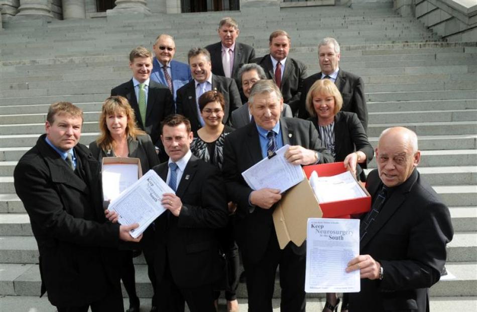Murray Kirkness (front left) and Fred Tulett (front right) present neurosurgery petition forms to...