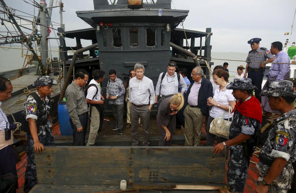 Myanmar government and UN officials inspect a boat used for human trafficking. Photo: Reuters