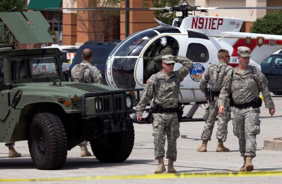 National Guard troops walk through a staging area inside a shopping centre parking lot in...