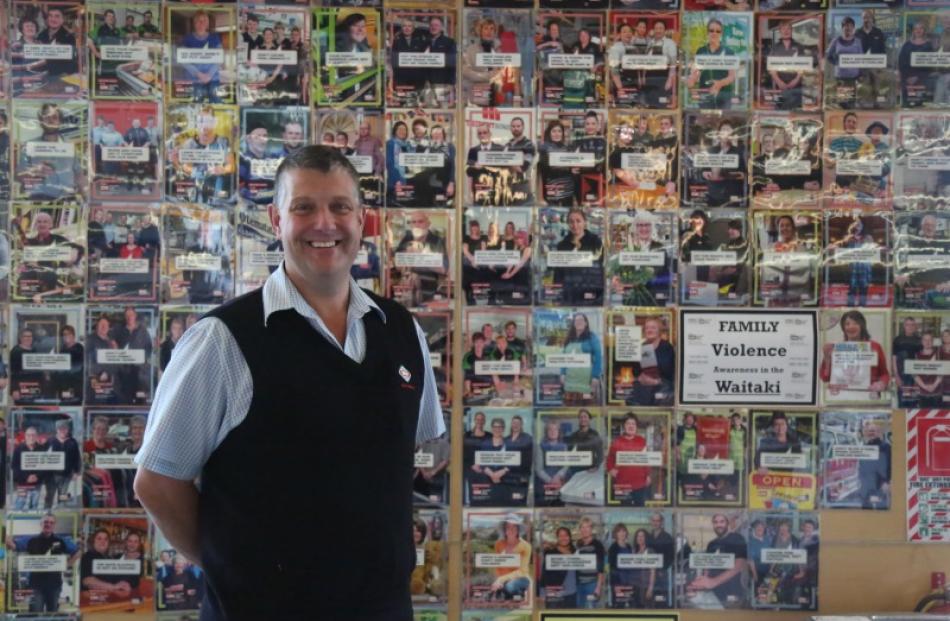 New World Oamaru owner Justin Smith stands by a display of all of the posters of the Waitaki It's...