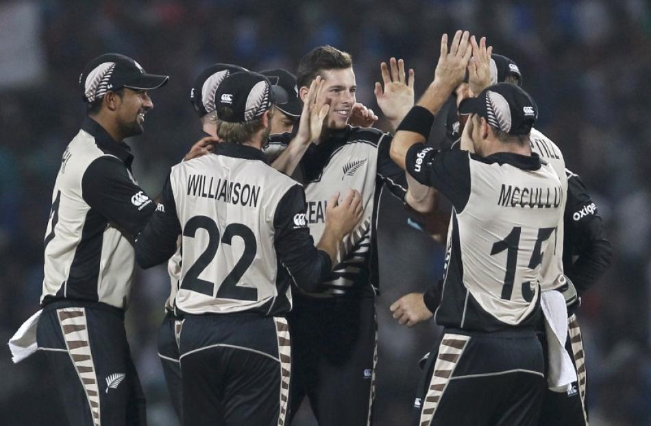 New Zealand's Mitchell Santner celebrates taking a wicket with his team. Photo: Reuters