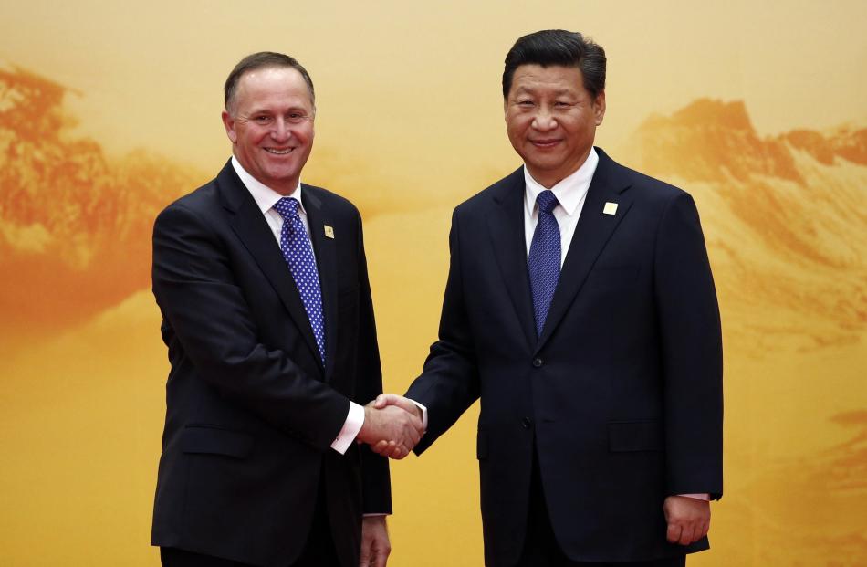 New Zealand's Prime Minister John Key (L) shakes hands with China's President Xi Jinping during a...