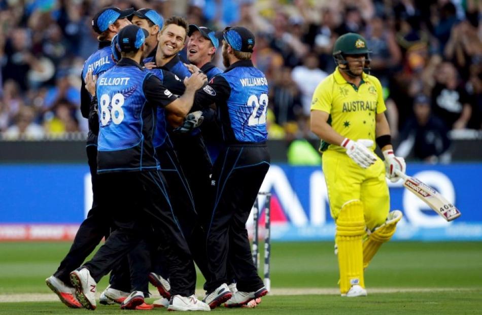 New Zealand's Trent Boult (C) is surrounded by teammates as they celebrate his dismissal of...