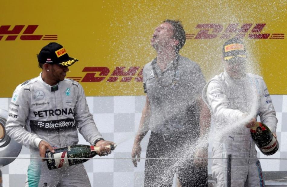 Nico Rosberg (R) and Lewis Hamilton splash each other with champagne after the Austrian Grand...