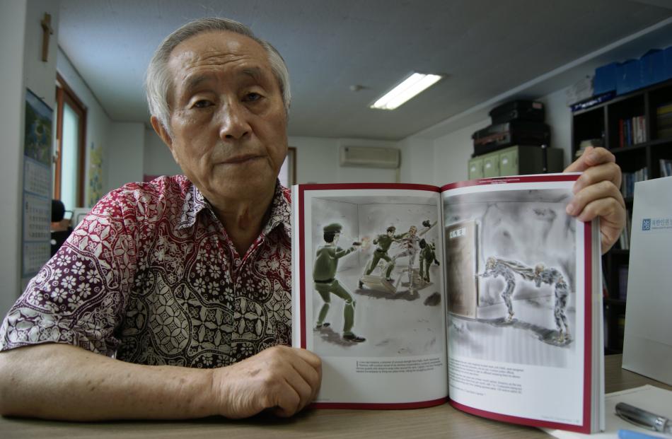North Korean exile Kim Sang Hun with his book detailing abuse in the secretive country. Photo by...
