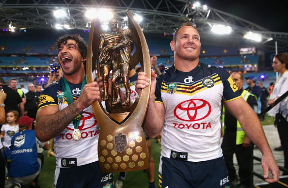 North Queensland's Johnathan Thurston (L) and Matthew Scott carry the trophy as they leave the...