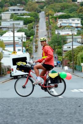 Northeast Valley postman Kerry Wheeler passes Baldwin St on his round yesterday morning. Photos...