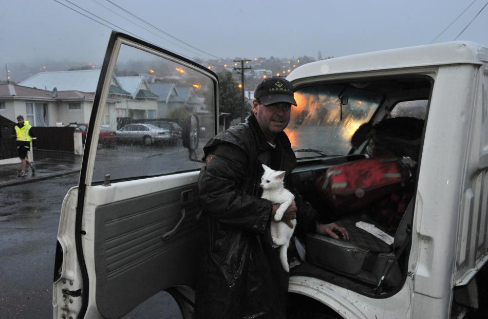 Northeast Valley resident Marty Duffy leaves  with his cat Honky after a slip opened up a '...