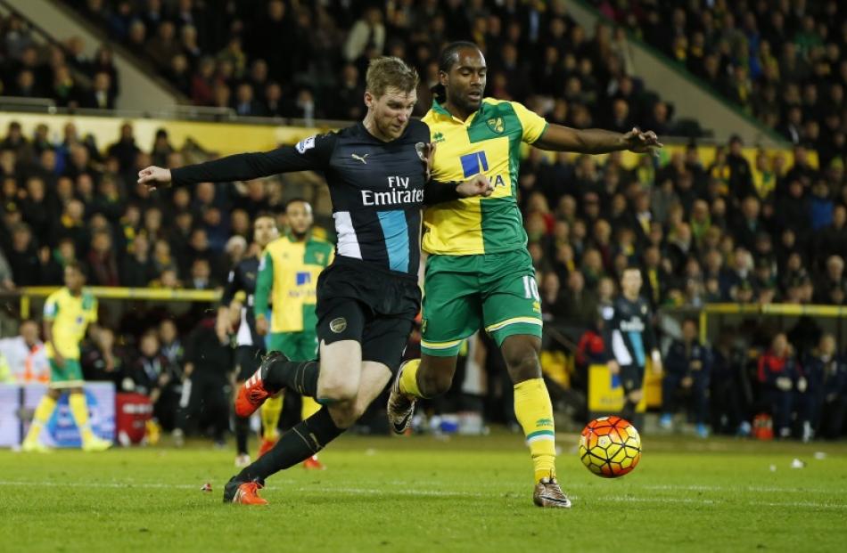 Norwich City's Cameron Jerome and Arsenal's Per Mertesacker challenge each other for the ball....