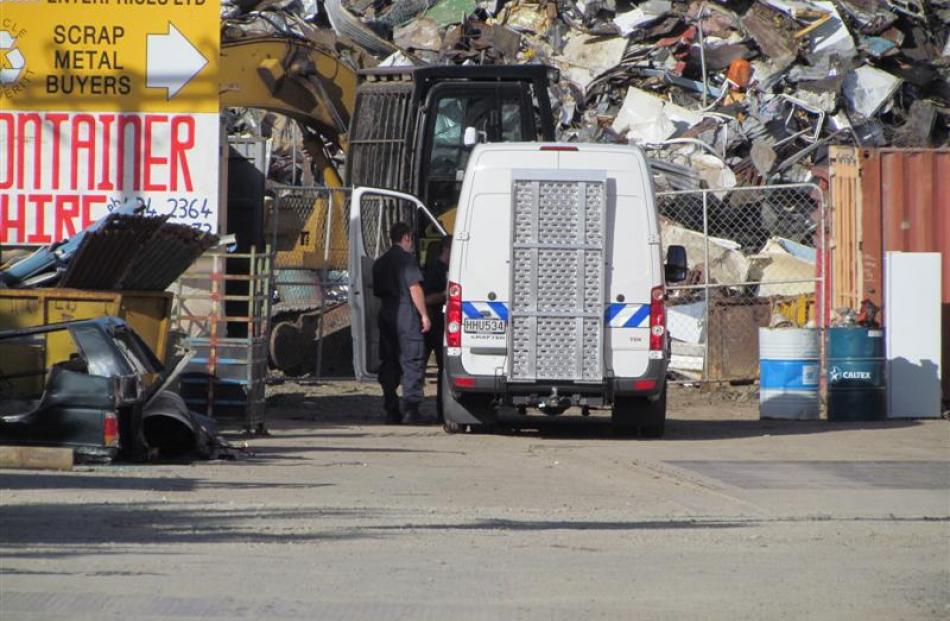 NZ Army explosives disposal experts yesterday retrieve a bucket of explosives from a scrapyard in...