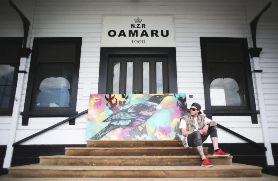 Oamaru artist Jesse Geary sits by the centrepiece of his latest exhibition, Tui, at  Oamaru...