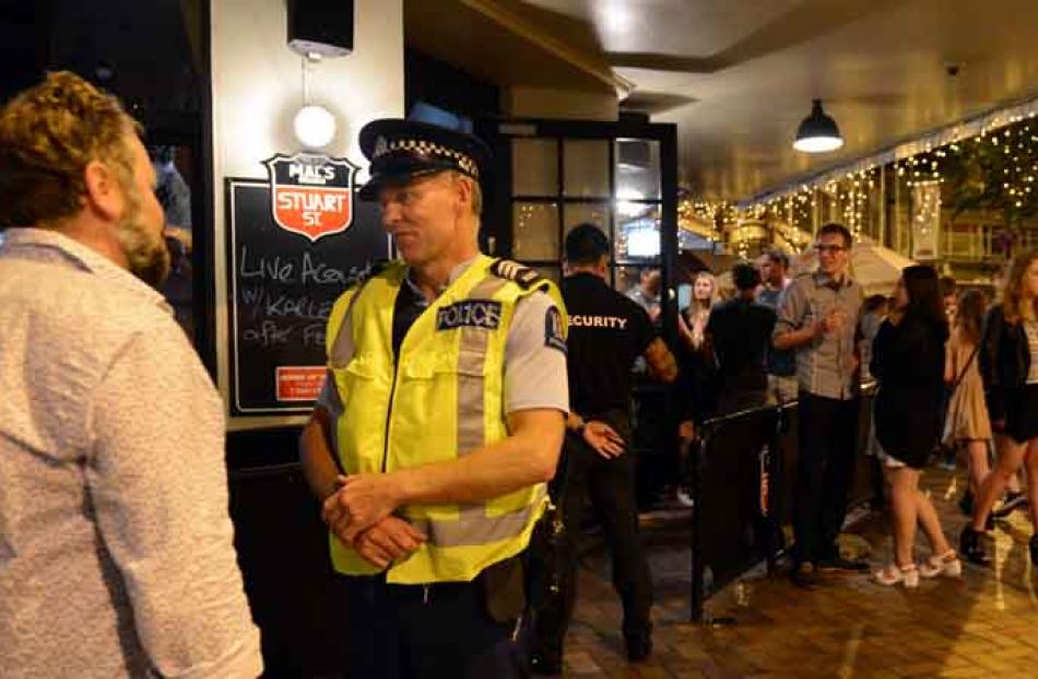 Sergeant Ian Paulin, of  Dunedin, talks to a bar patron in the Octagon on Saturday night. Photos ...