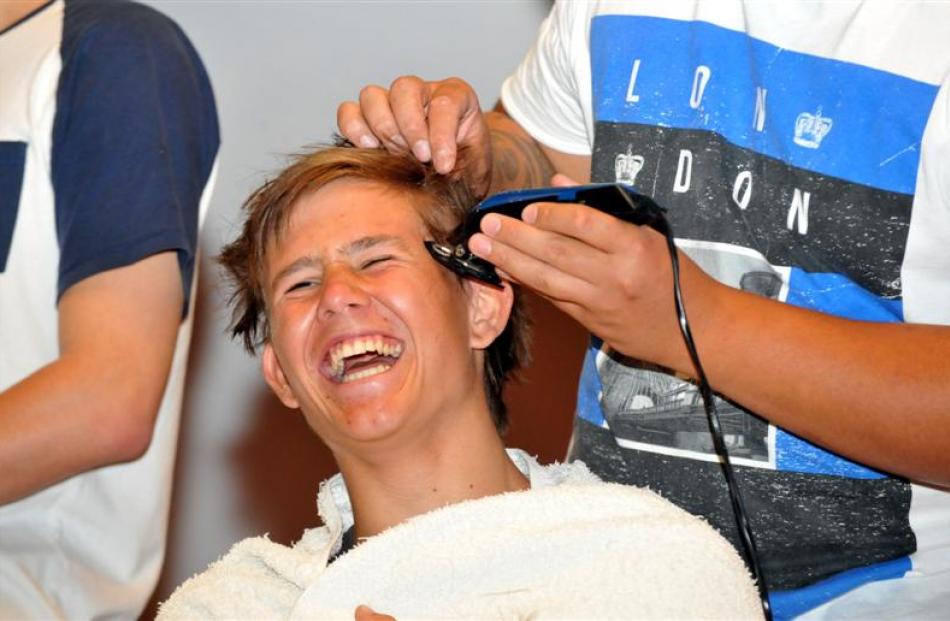 Otago Boys' High School pupil Ted Brown (17) laughs as his head is shaved. Photo by Gregor...