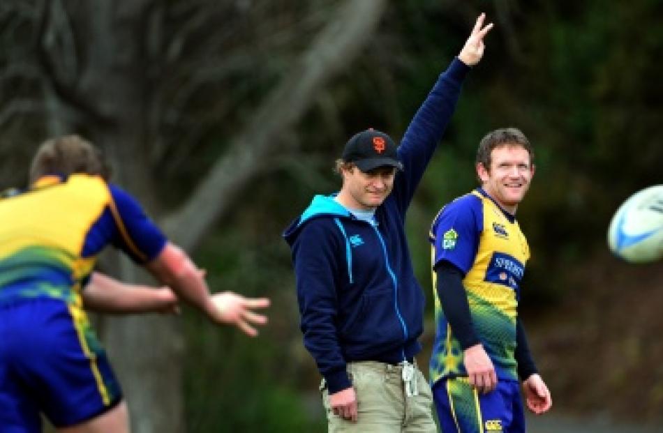 Otago coach Tony Brown makes a signal with first five-eighth Peter Breen beside him at training...