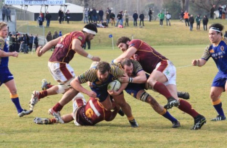Otago hooker Liam Coltman drives through a Southland tackler with the support of lock Joe Latta...