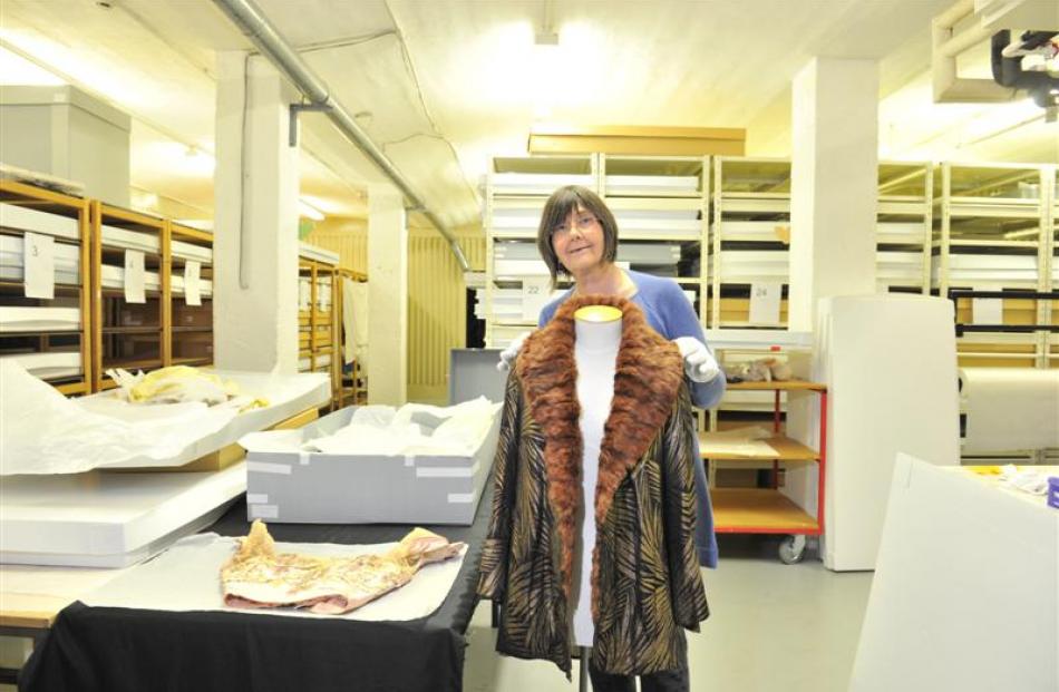 Otago Museum honorary curator of dress Dr Jane Malthus examines an evening jacket in metallic...